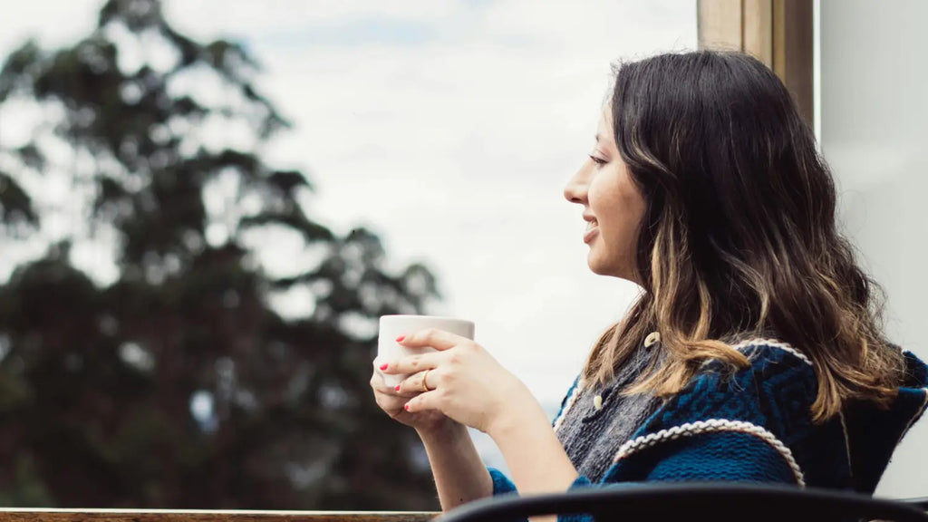 Woman drinking coffee in the balcony