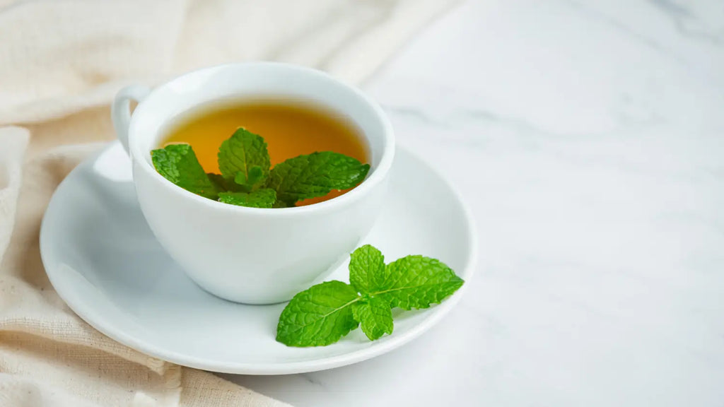 Cup of peppermint tea and peppermint leaves