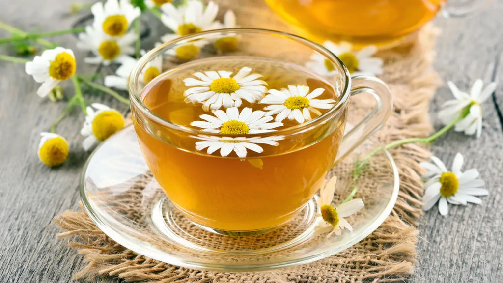 Cup of chamomile tea and chamomile flowers