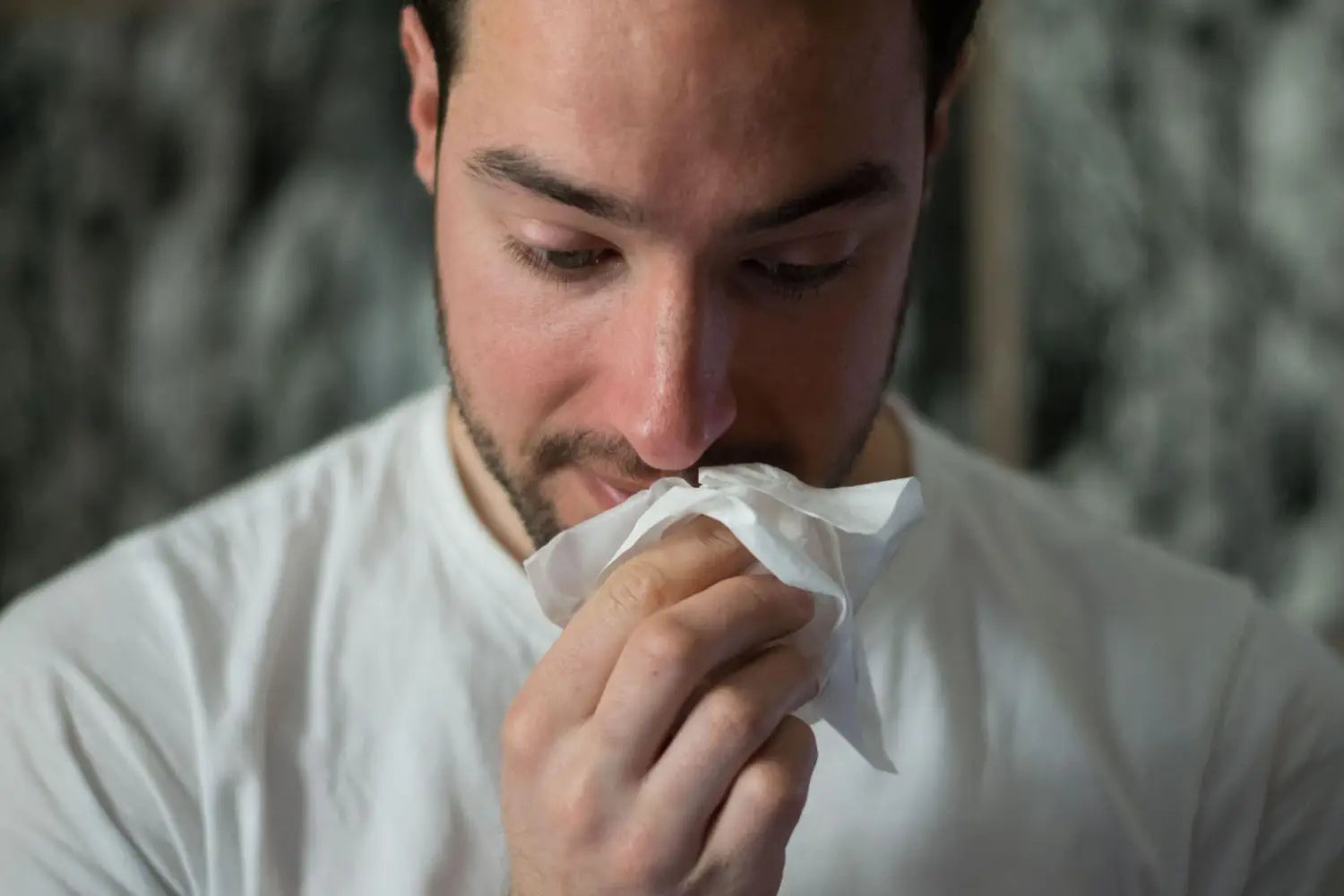 Man blowing his nose.