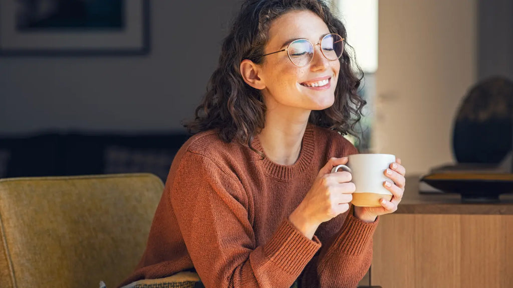 Woman smiling while holding cup of tea