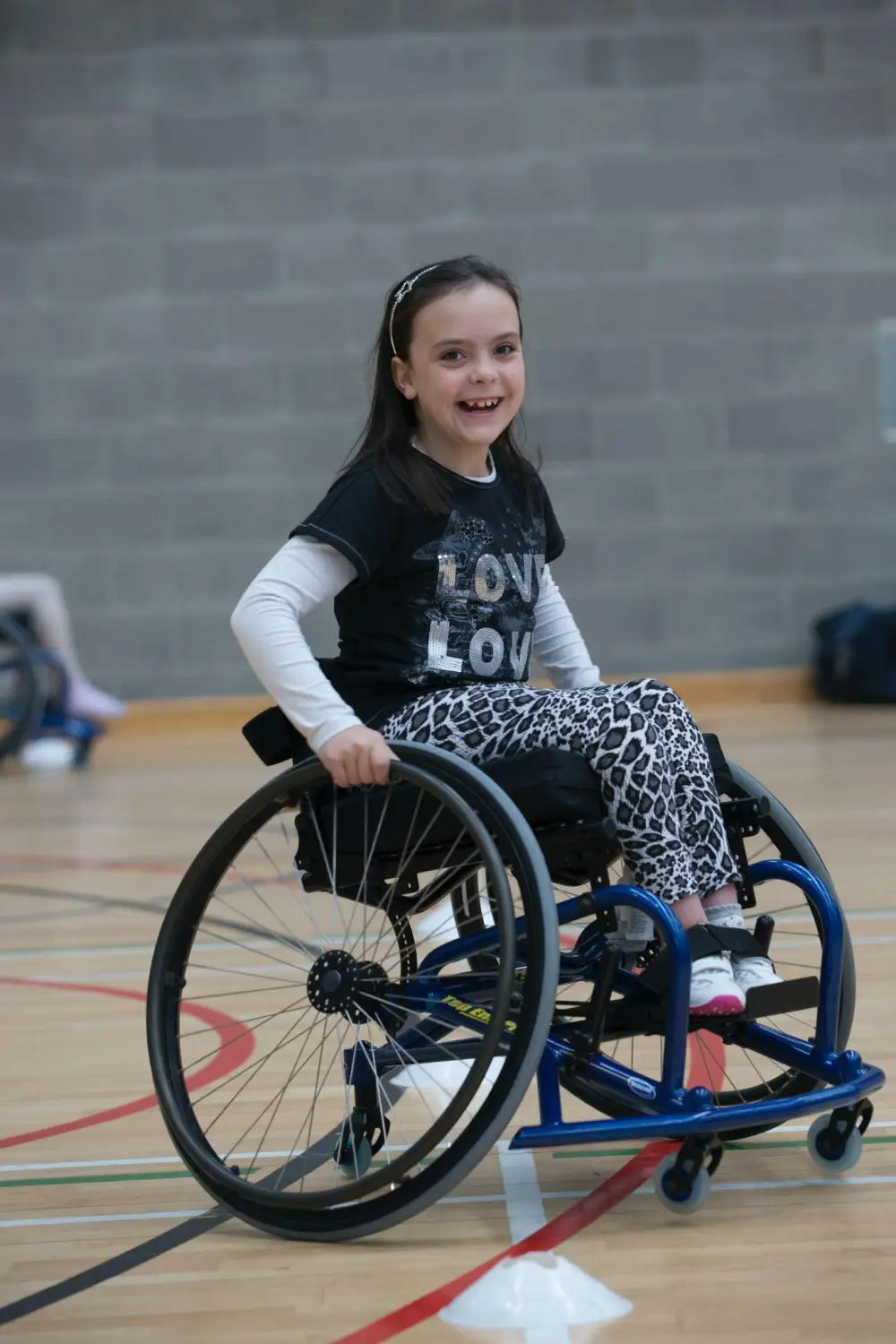 child in wheelchair smiling.