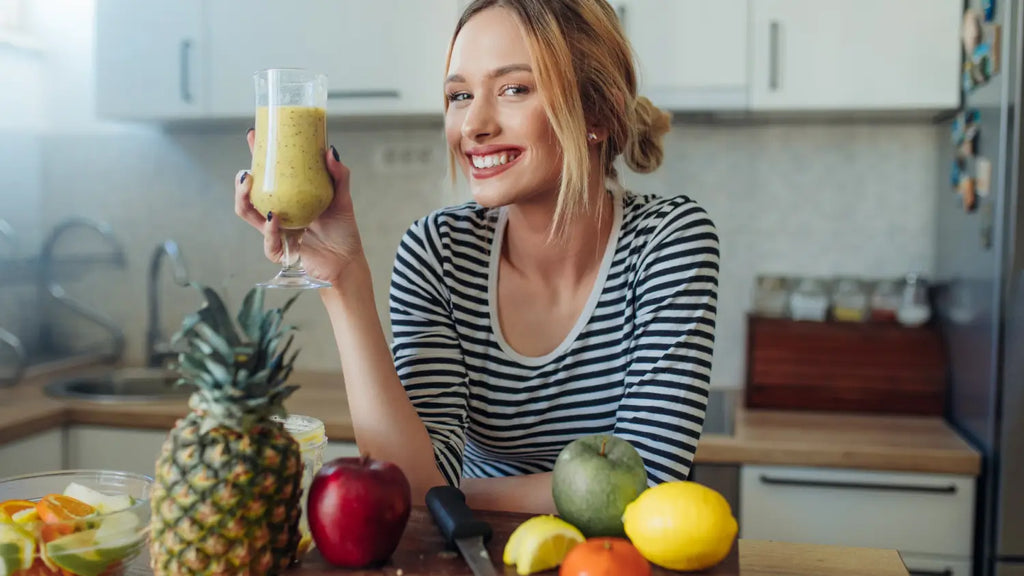 Woman holding smoothie glass and smiling