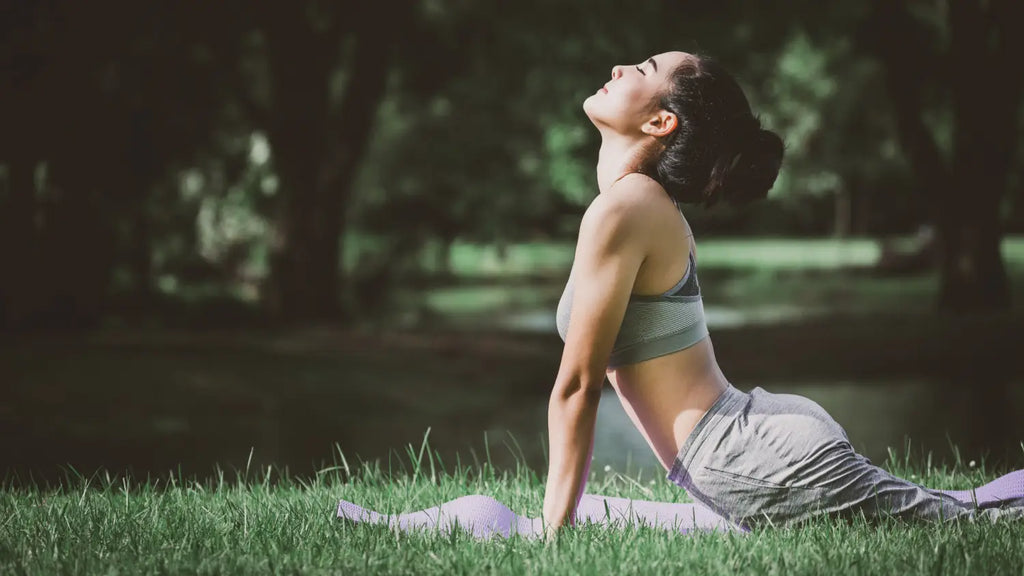 Woman practicing yoga outdoors in park