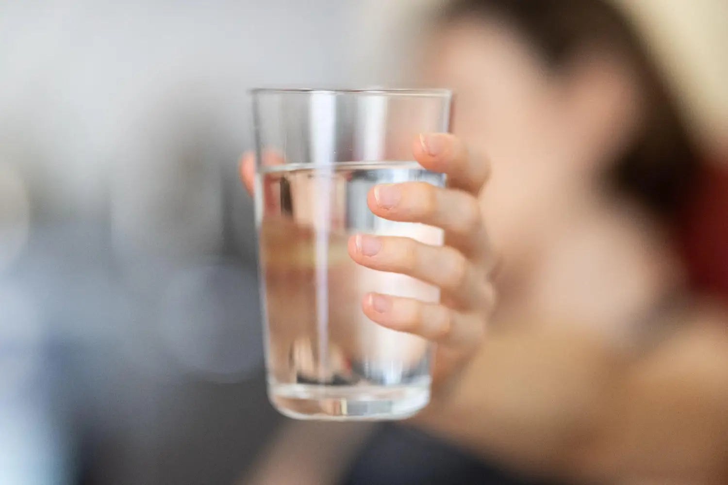 Person holding a glass of water.