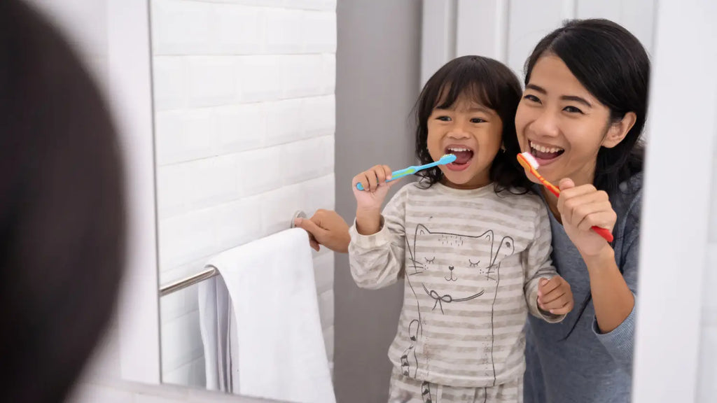 Mom and child brushing teeth together