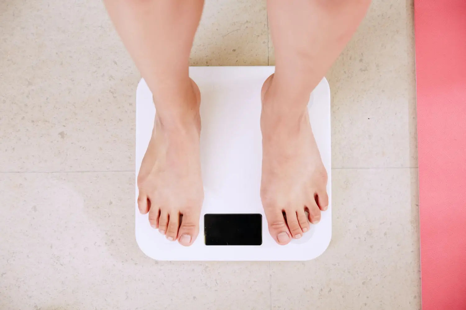 person weighing themselves on a scale.