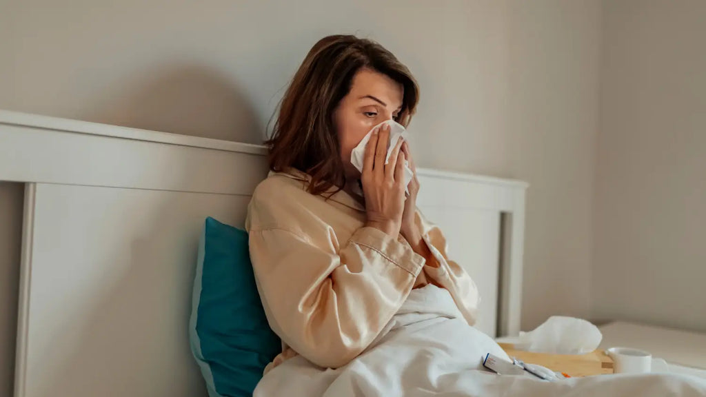 Woman laying in bed struggling with a cold