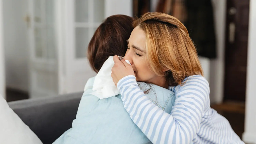 Woman crying while hugging friend