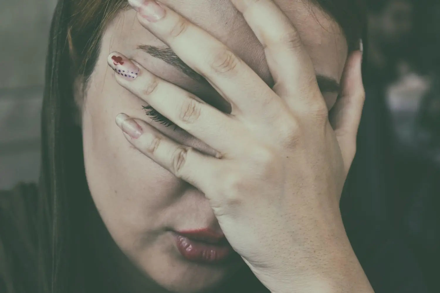 woman touching her forehead.