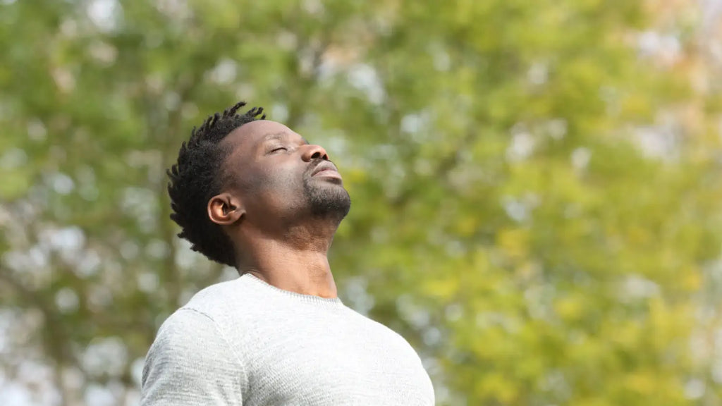 Man taking a deep breath outdoors