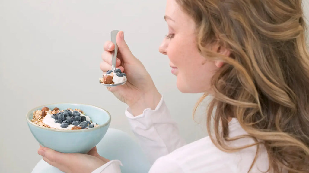 Woman eating healthy breakfast yorgut bowl