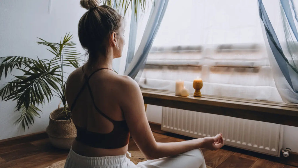 Woman meditating near window