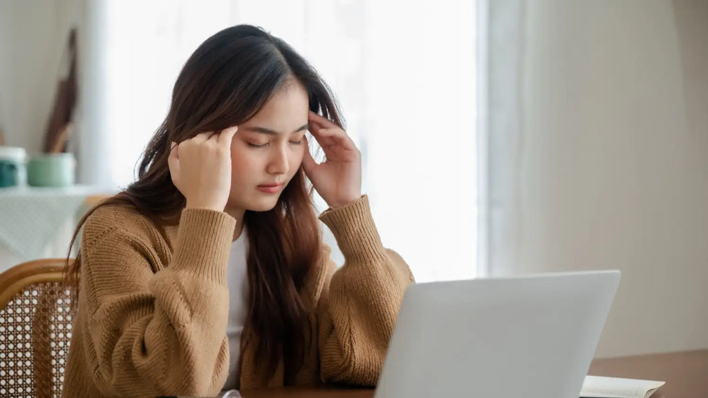 Woman feeling tired while working on her laptop