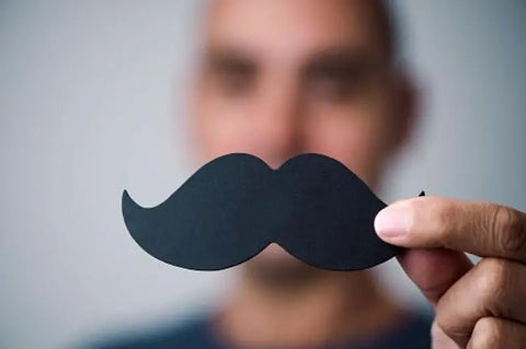 Man holding a cardboard mustache