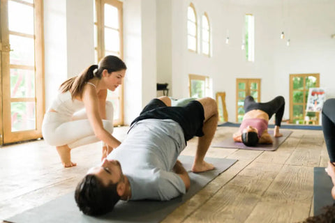 Yoga class performing bridge pose