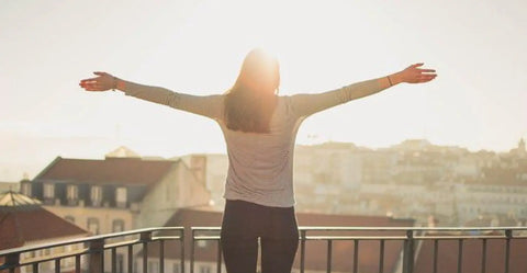 Woman with open arms enjoying the landscape.