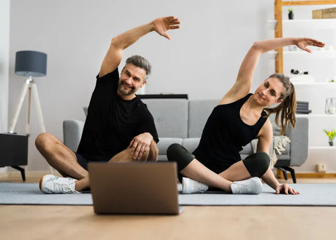 Couple doing an online yoga class at home