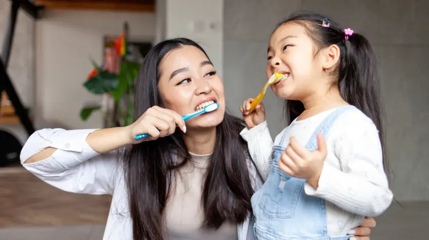 Mum and daughter brushing teeth together