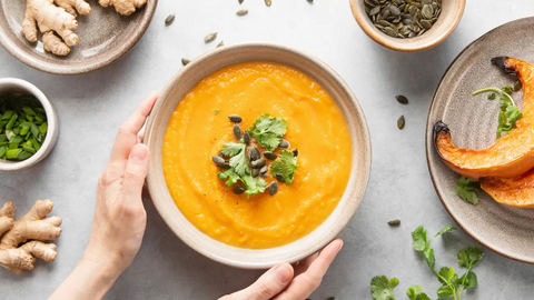 Bowl of soup, seeds, roasted vegetables and ginger