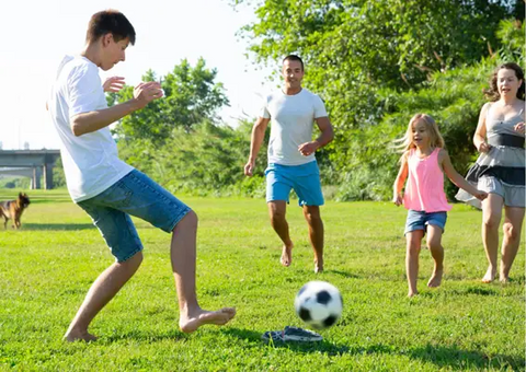 Kids and teenagers playing soccer together