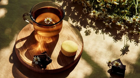 Herbal tea, chamomile flowers, and macaron dessert outside in the terrace.