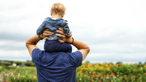 Father with son piggybacking in garden