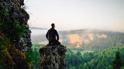 Man sitting on top of mountain