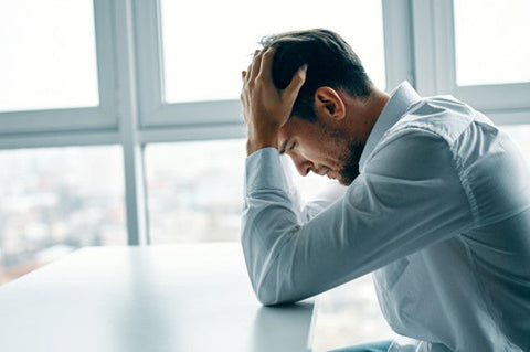 Man holding his head in his hands.