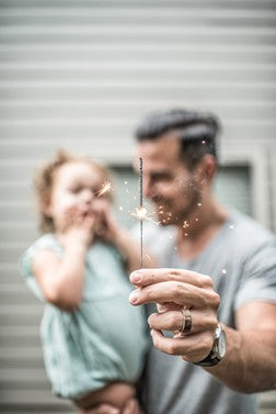 Man with child in his arms holding a candle.