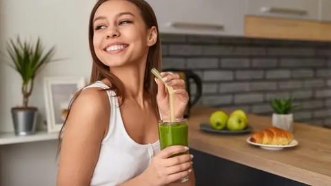 Woman drinking a green smoothie