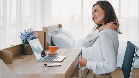 Woman suffering from neck pain while working