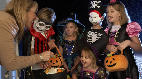 Group of kids receiving candy on Halloween