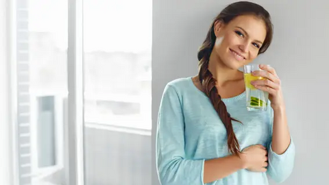 Woman with a glass of lemon water in her hand