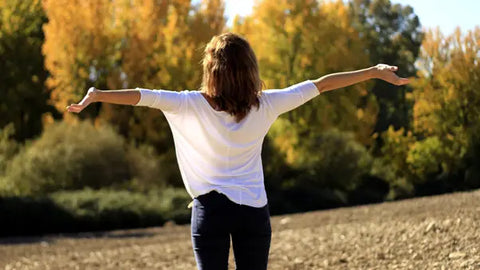 Woman with open arms in nature