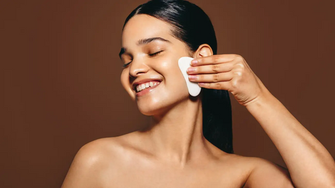 Woman massaging her face with a gua sha