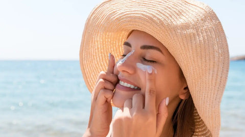 Woman applying sunscreen on her face