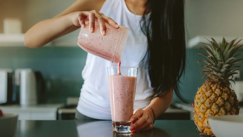 Woman pouring smoothie into a glass