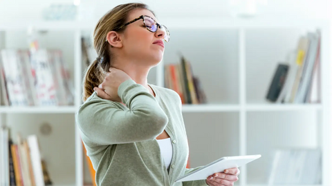 Woman suffering from neck pain while working