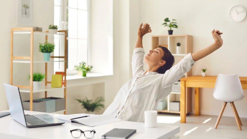 Woman stretching at desk while working