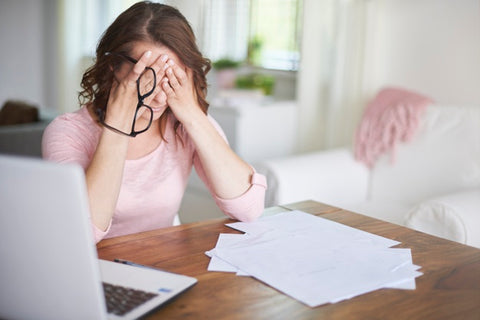 Woman looking stressed with hands on face.