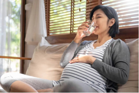 Pregnant woman drinking a glass of water