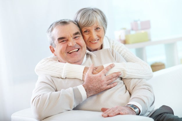 Old couple hugging and smiling.