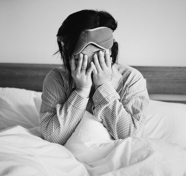 Woman holding head in hands.